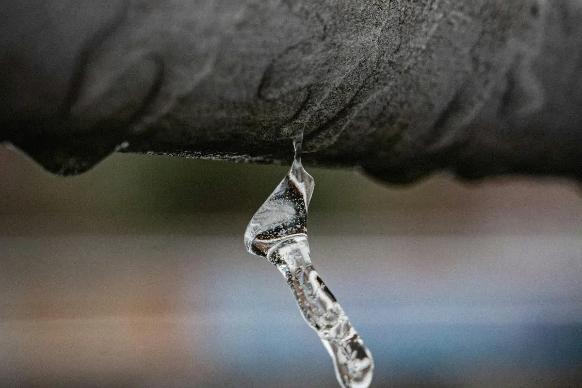 An icicle hanging from the underside of a pipe